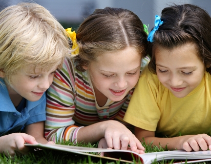 three kids look at a book