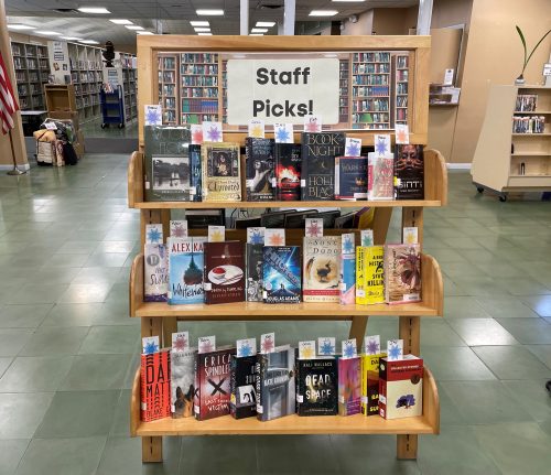 A three level book shelf with a sign on top that says Staff Picks! and books on all three levels