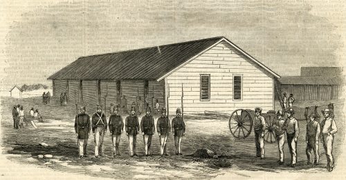 A wooden building with a row of soldiers in front and groups of men standing on either side.