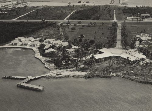an aerial view of a waterfront with a pier and buildings.
