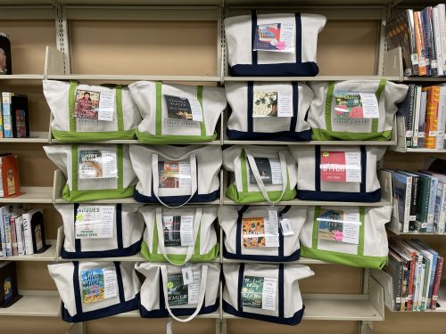 Five rows of tote bags on book shelves