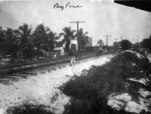 A woman stands on railroad tracks. Big Pine is written on the photo.