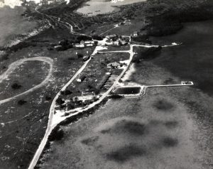 Aerial view of an island with roads and several extended causeways and docks.