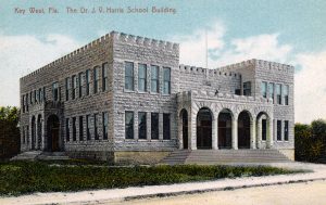 A two story concrete block building with porticos on two sides. Text reads Key West, FLa. The Dr. J.V. Harris School Building.