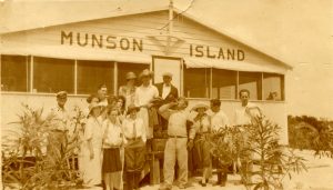 A group of people in front of a building with Munson Island painted on the front.