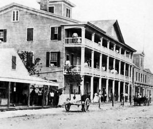 A three-story building with balconies on all levels with people on them.